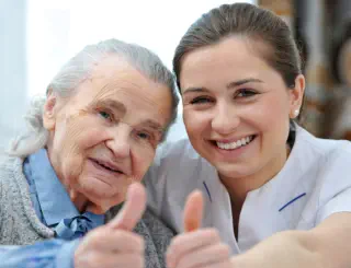 Eine glückliche Seniorin mit Pflegerin.