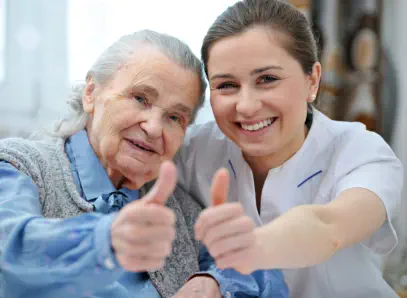 Eine glückliche Seniorin mit Pflegerin.